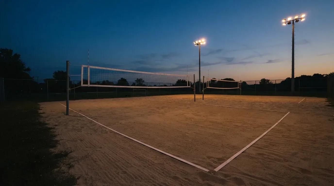 An empty football stadium with floodlight masts at dusk